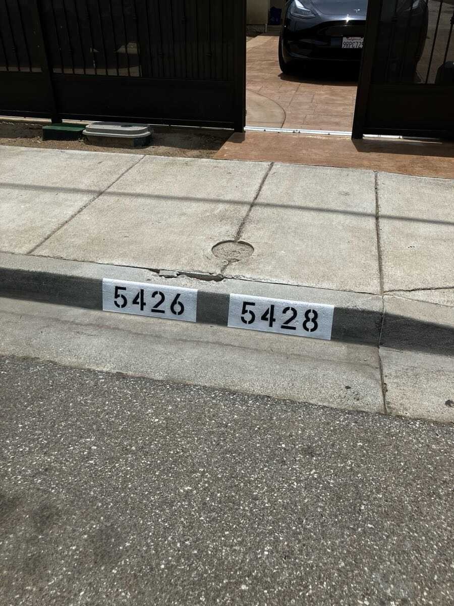 Double address 5426 and 5428 painted on a shared driveway curb