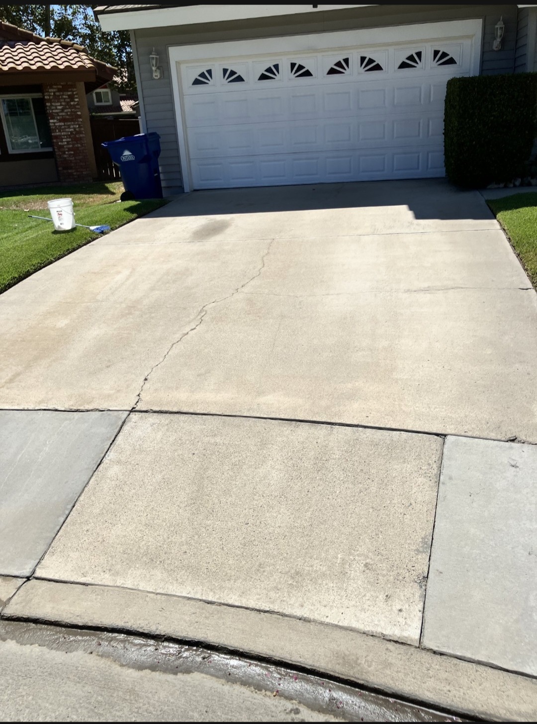 Freshly pressure washed concrete driveway in front of a home